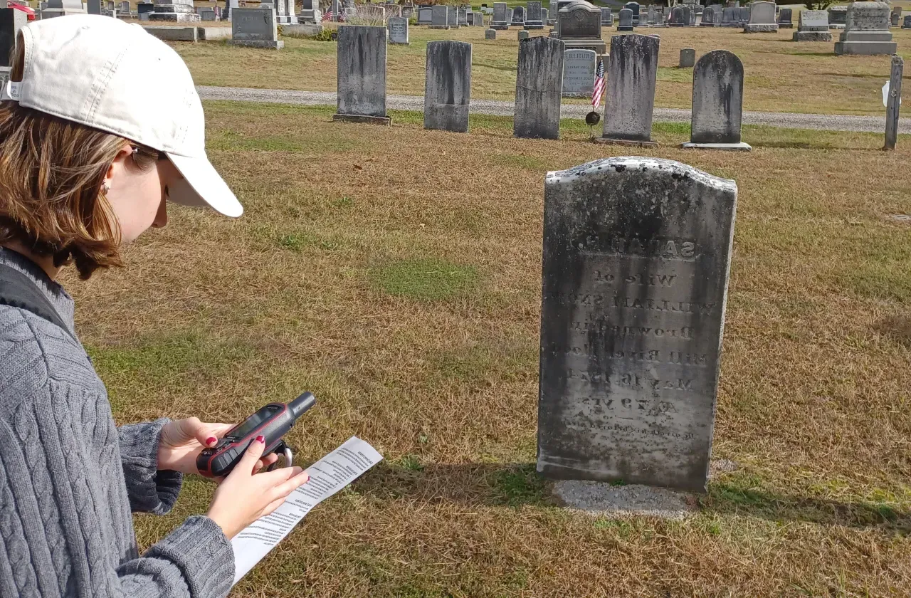 一名学生在墓地拿着追踪装置.